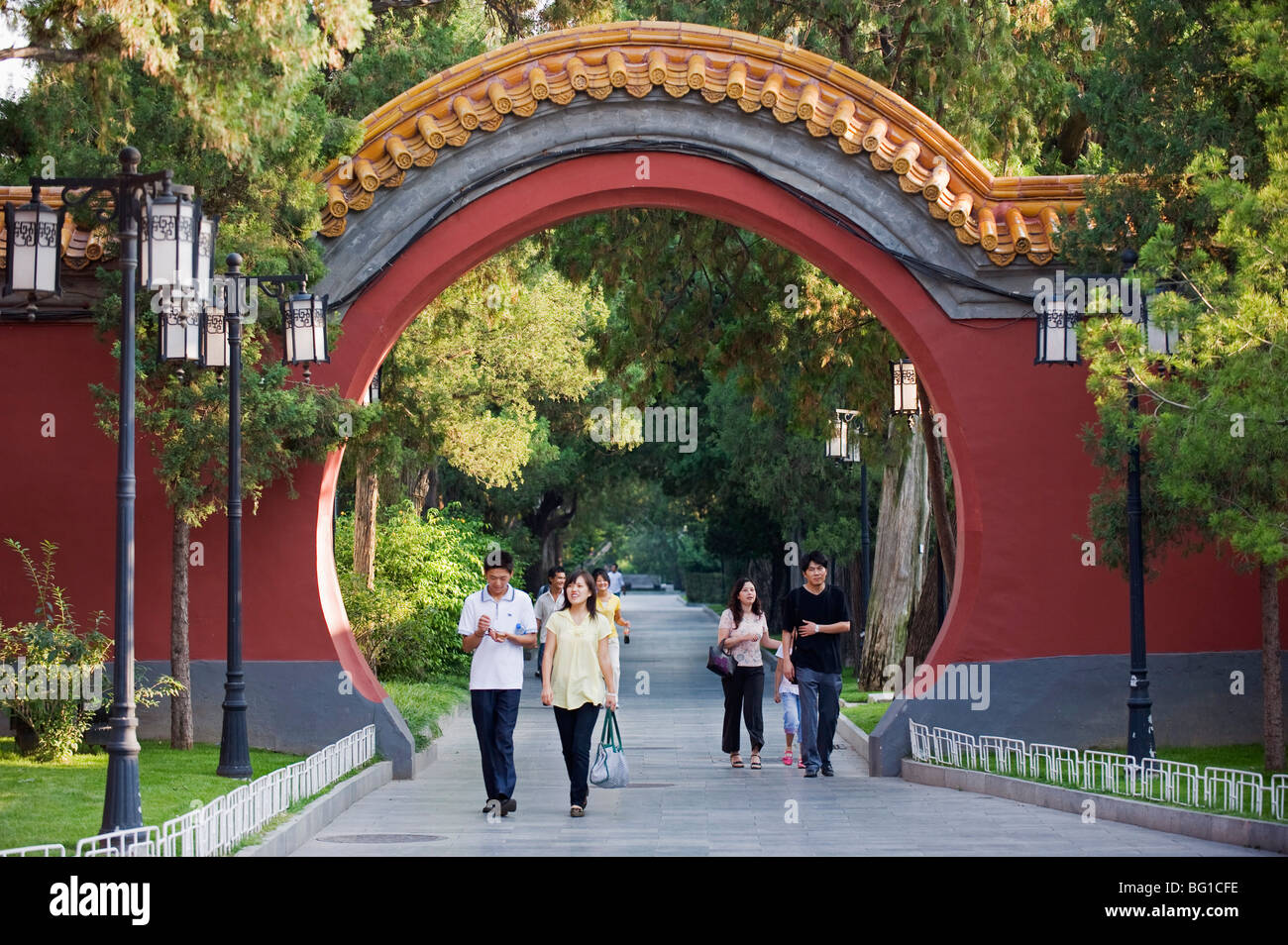 I visitatori a piedi attraverso un cancello ad arco a Zhongshan Park, Pechino, Cina e Asia Foto Stock
