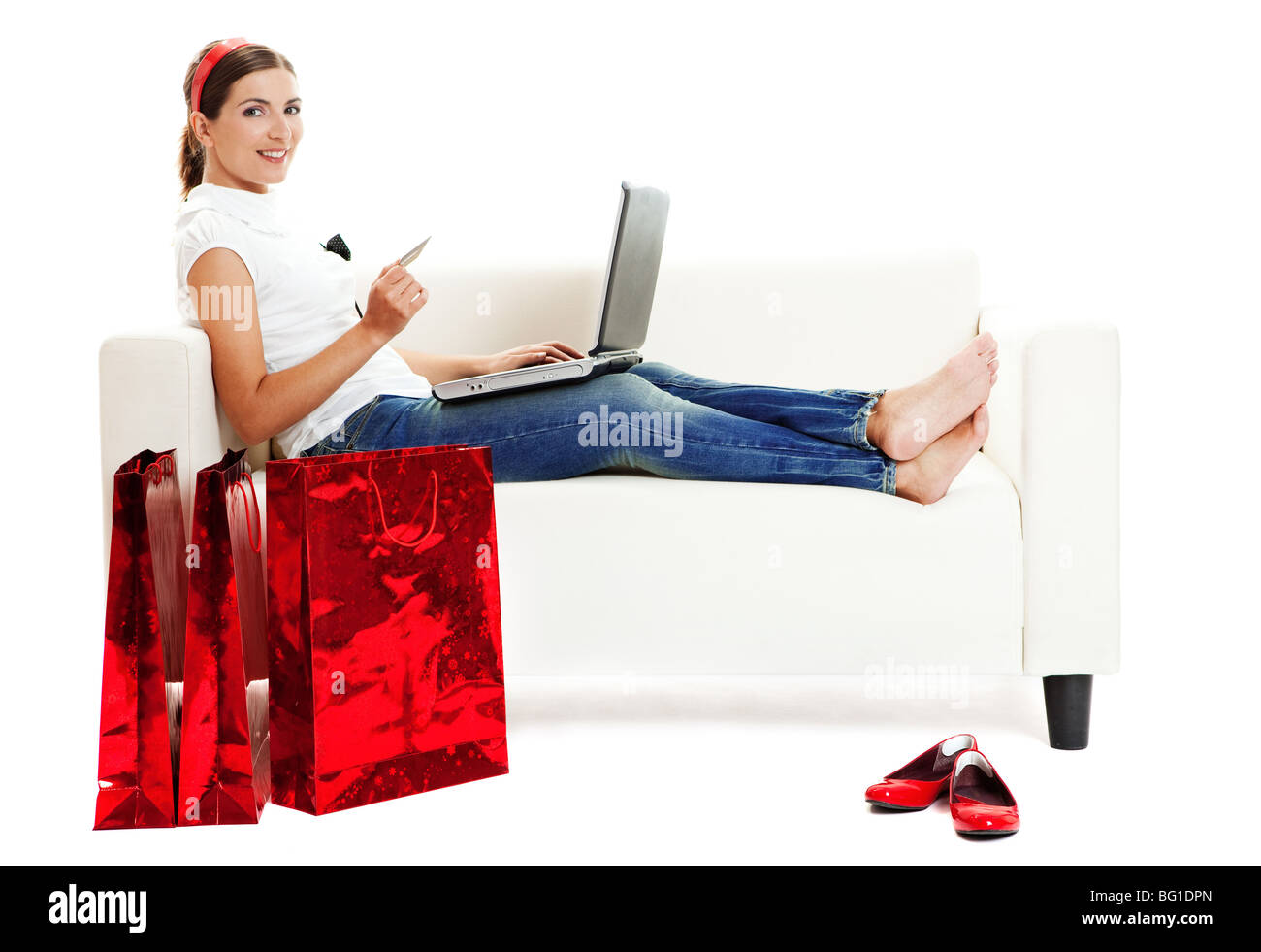 Bella giovane donna facendo negozi online con una carta di credito, il consumismo concept Foto Stock