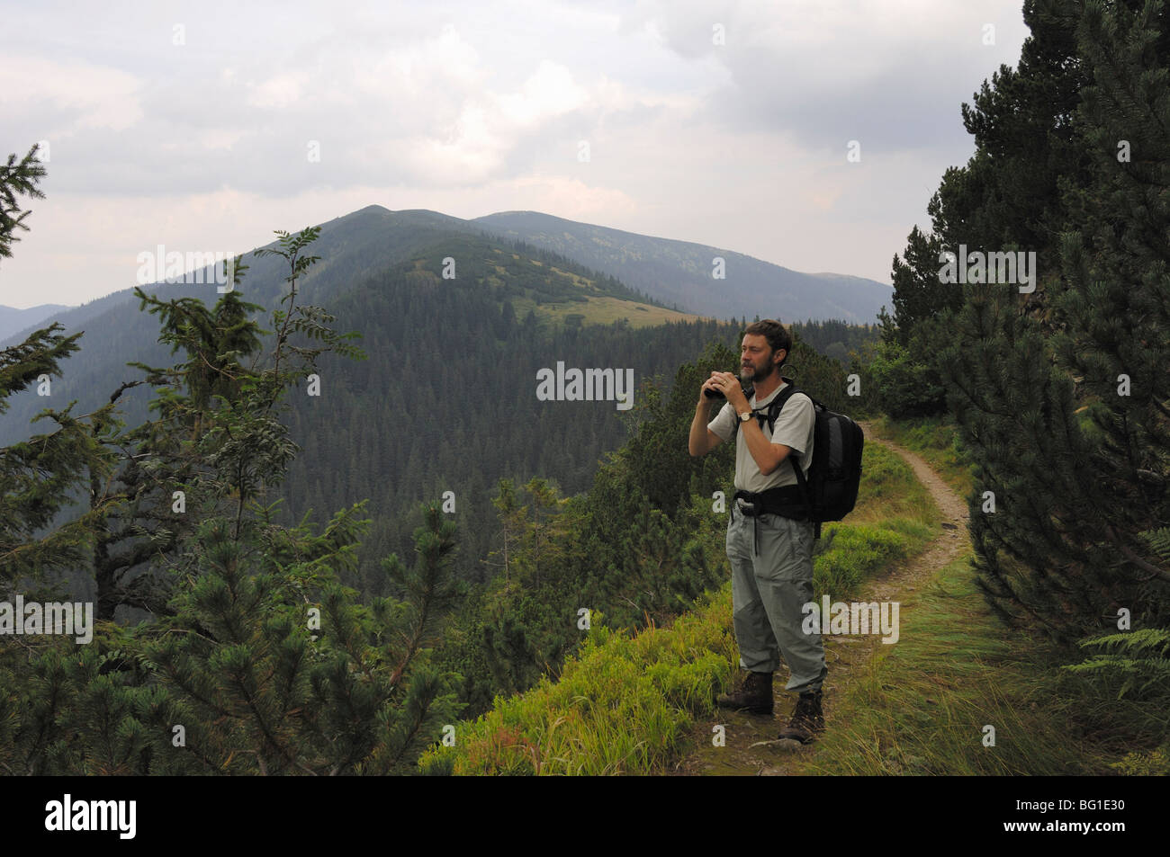 Walker usando il binocolo nei Bassi Tatra o Nizke Tatry in Slovacchia Foto Stock
