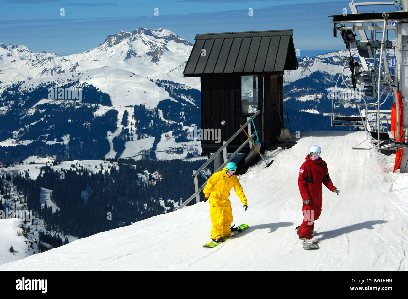 Gli appassionati di snowboard che arrivano in alto Chamossiere stazione a valle seggiovia nell area sciistica Morzine Avoriaz Alta Savoia, Francia Foto Stock