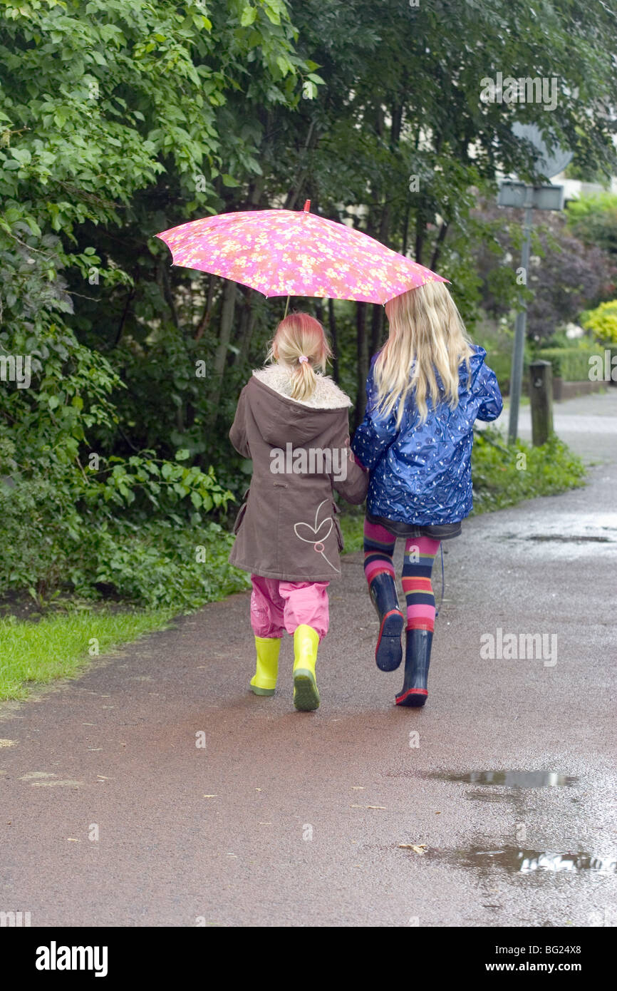 Giorno Di Pioggia I Bambini Che Vanno A Scuola La Condivisione Di Un Unico Ombrello Foto Stock Alamy