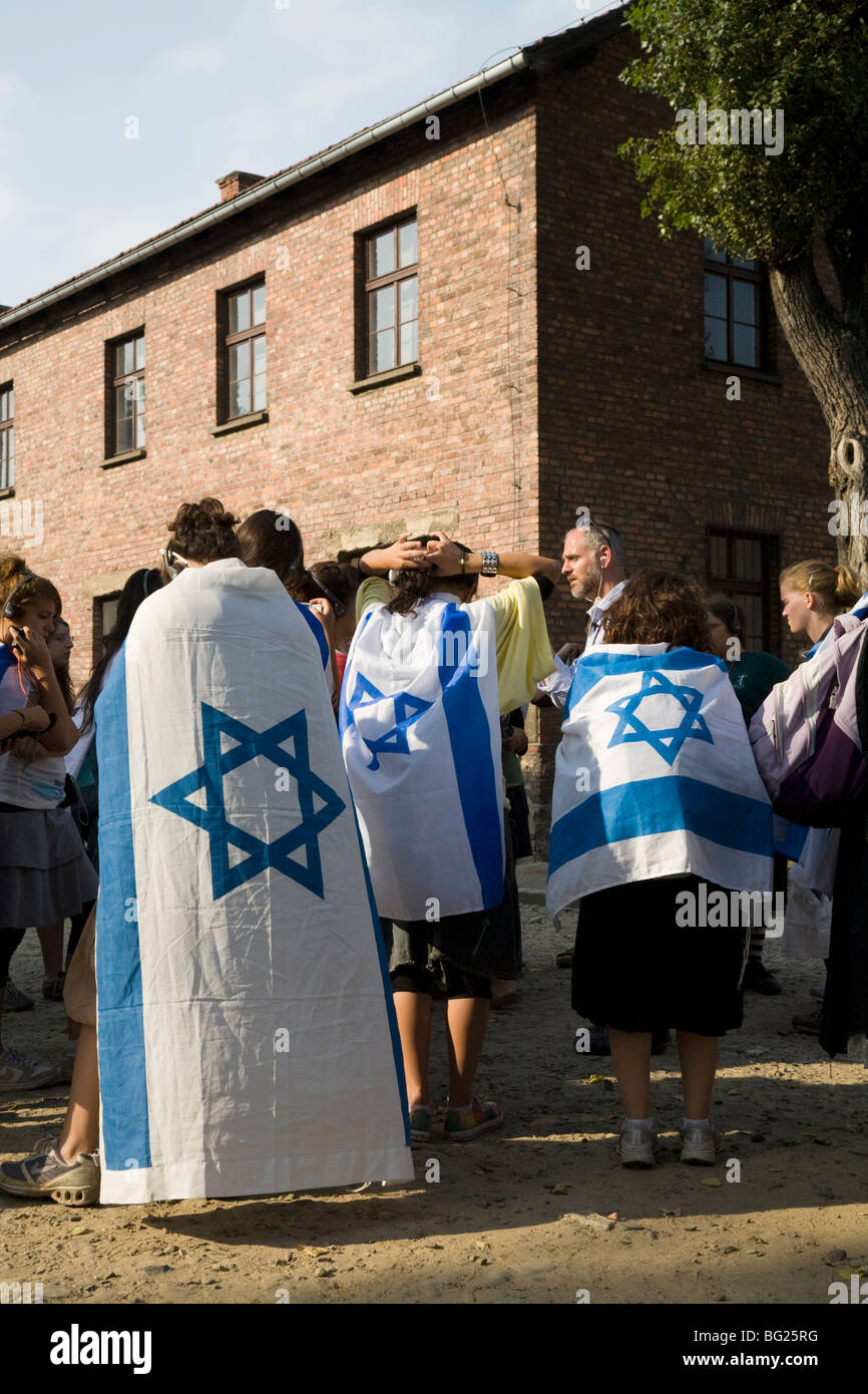 Scuola Ebraica / college bambini / studenti: gruppo su un tour di Auschwitz Nazi camp. La Polonia. Le ragazze sono indossando bandiere israeliane. Foto Stock