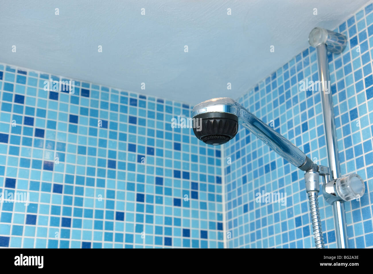 Testa di doccia nel bagno di blu di piastrelle a mosaico Foto Stock