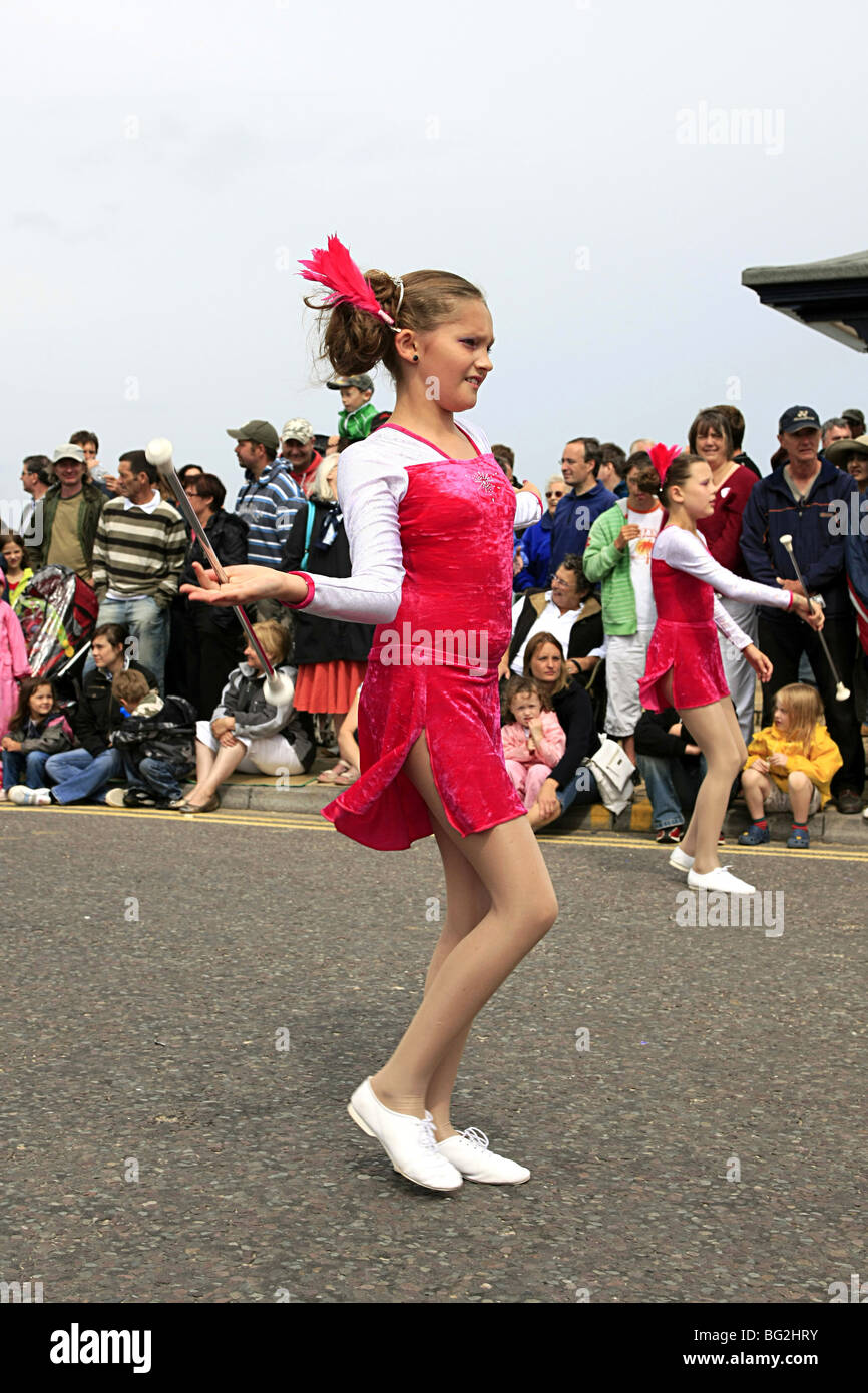 Ragazza adolescente di vorticazione manganelli di lei in una majorette sfilata in Inghilterra Foto Stock