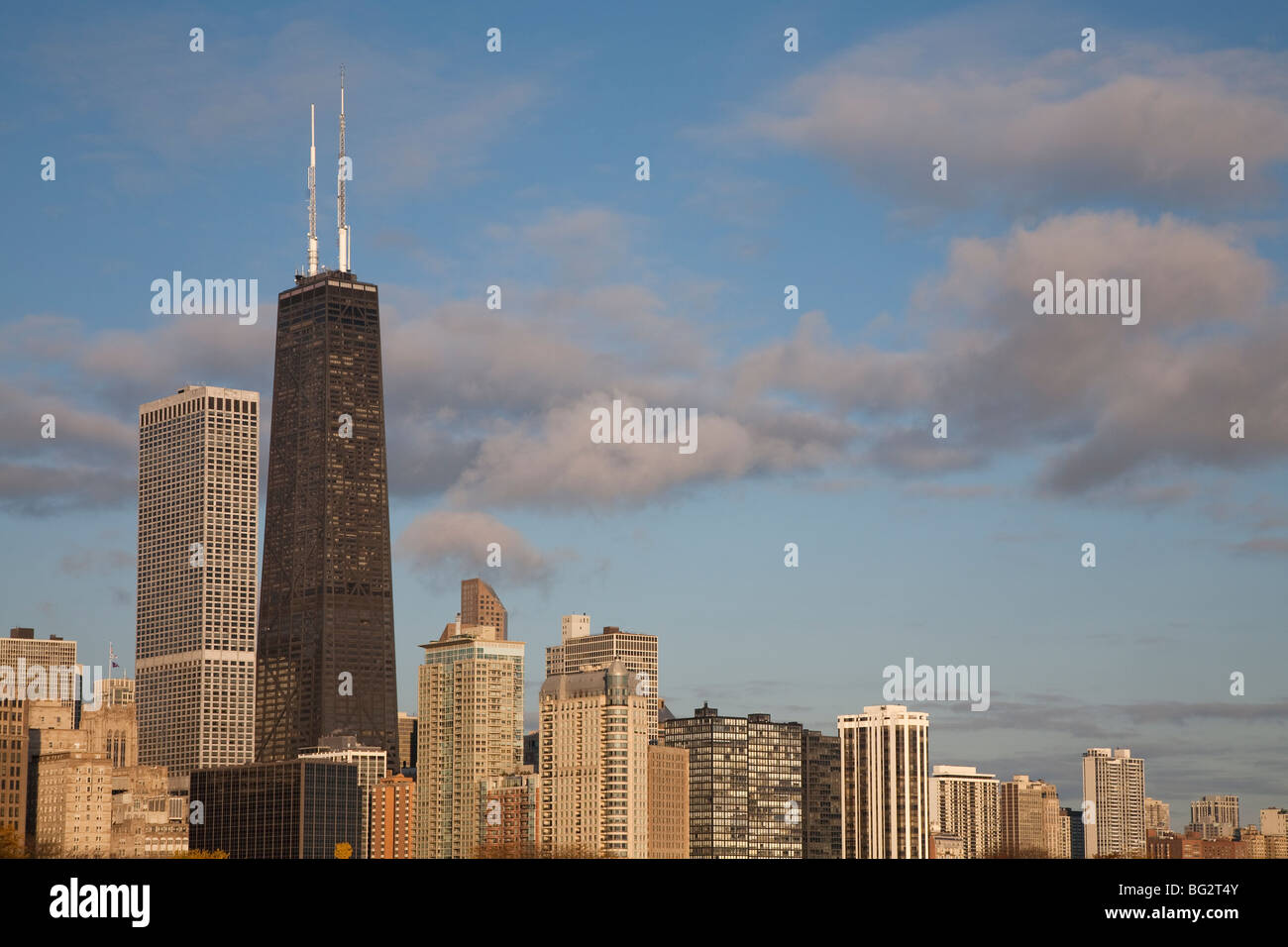 John Hancock Center tower e lo skyline del nord della città di Chicago contro un cielo blu con nuvole soffici Foto Stock