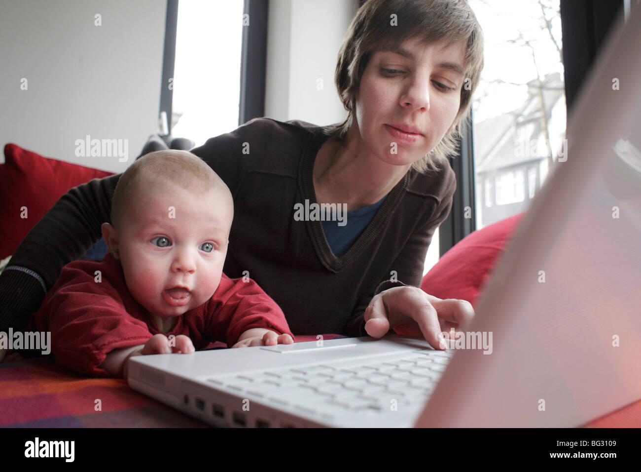 La madre e il bambino di lavoro su un computer portatile Foto Stock