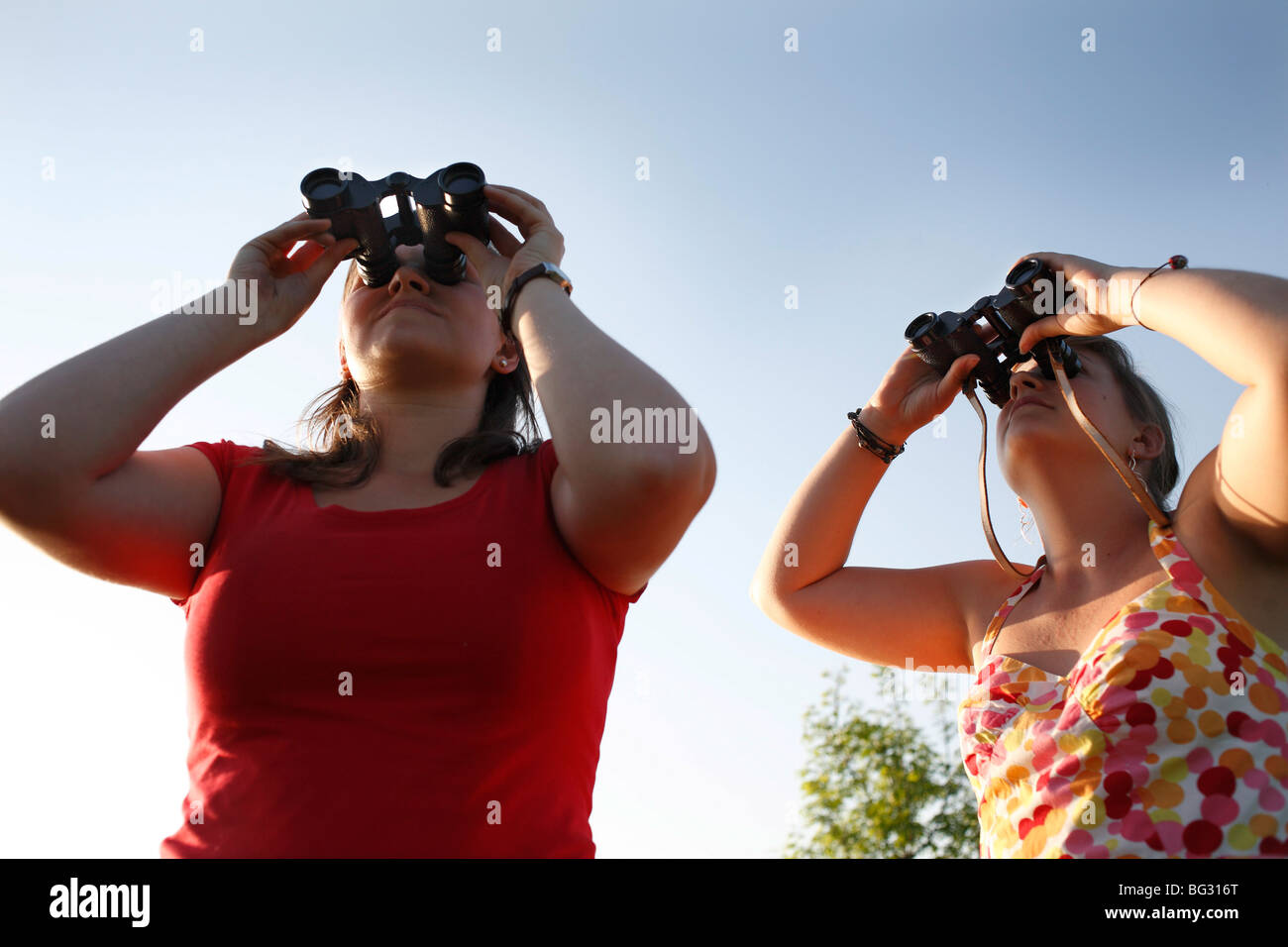 Giovani donne con il binocolo Foto Stock