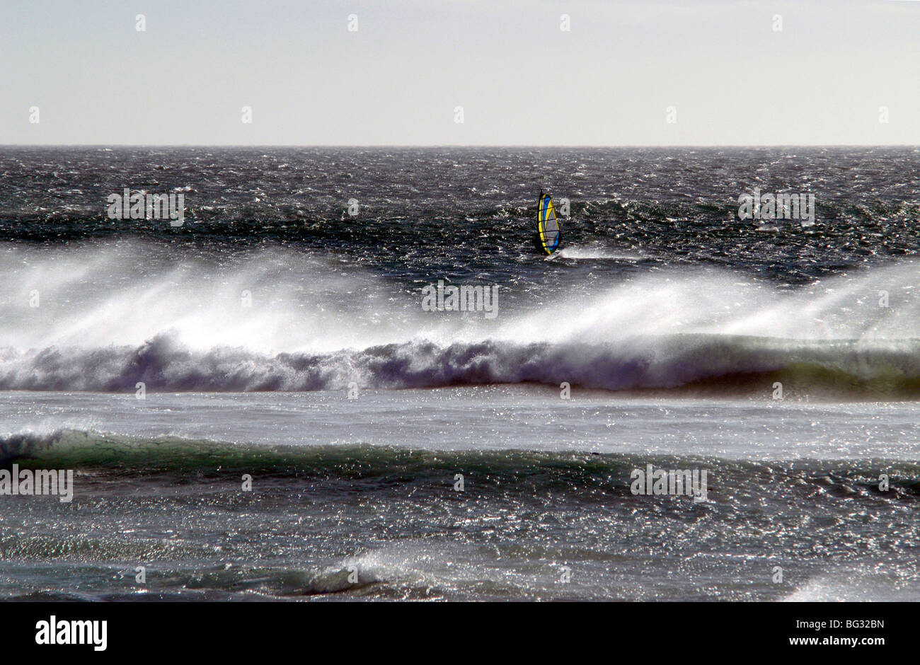 Un windsurf battaglie le onde dell'Atlantico e un forte vento southeaster a Scarborough, Cape Town, Sud Africa, 2006 Foto Stock