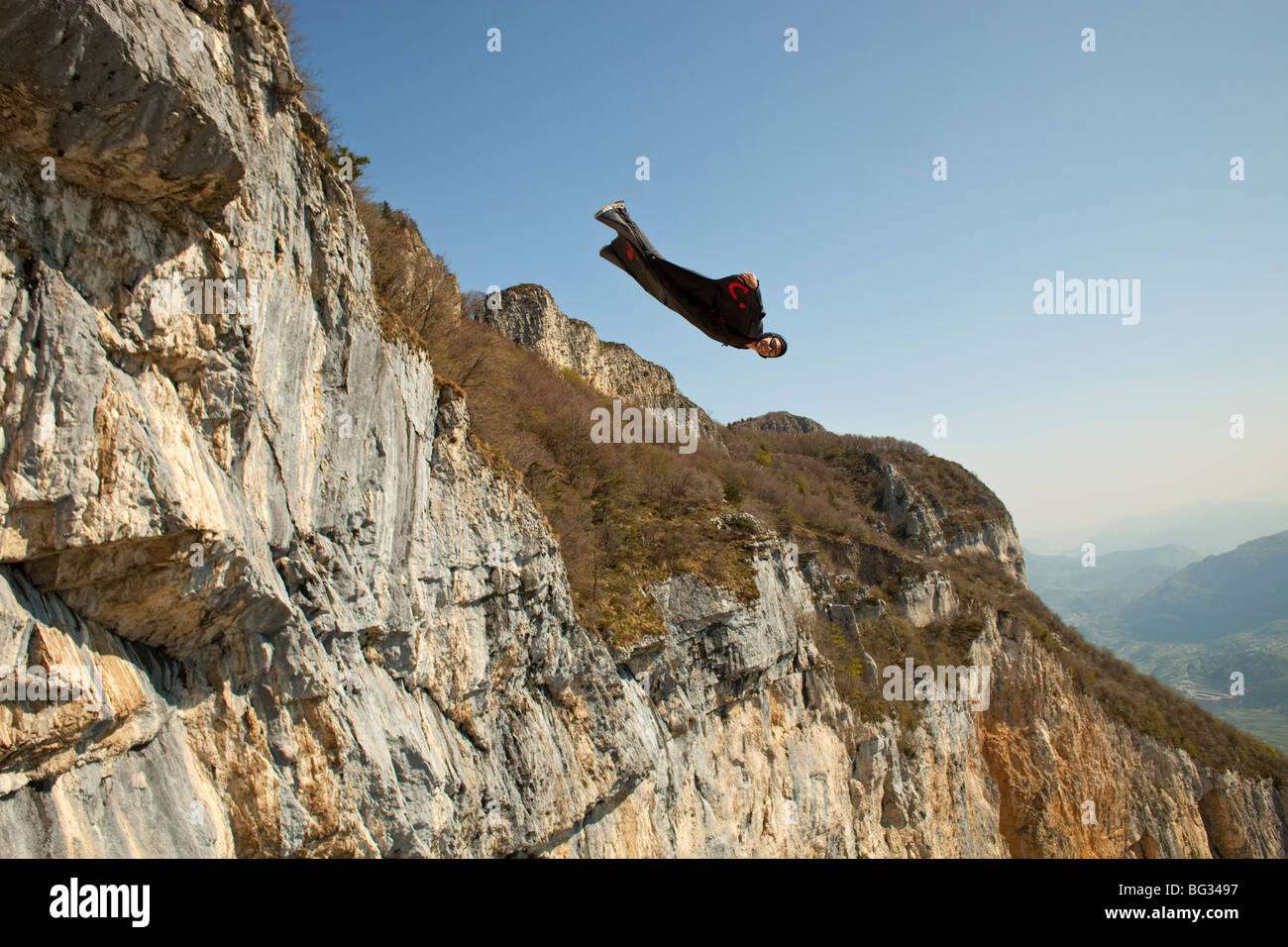 BASE jump da una scogliera. La ultimate kick per fare un salto in oggetto con una wingsuit su volare e di prossimità lungo la montagna. Foto Stock