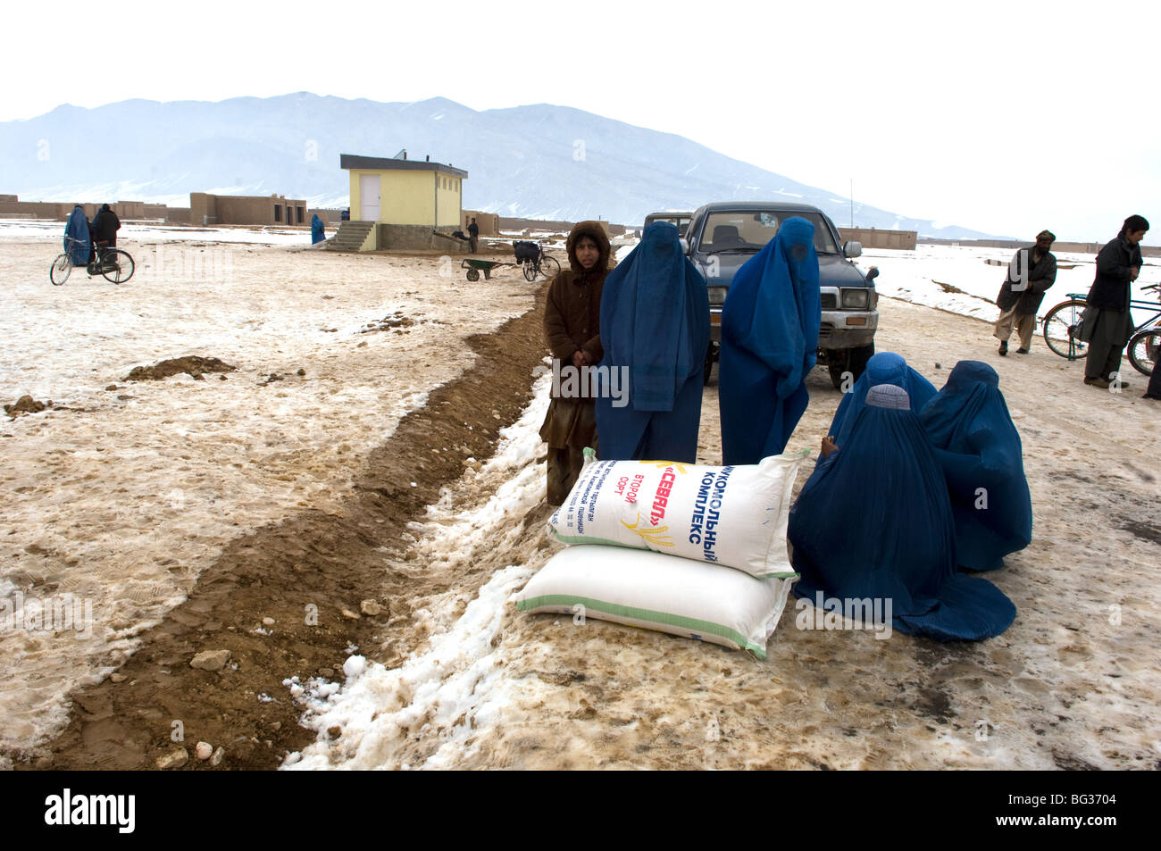 Poveri famiglie afghane ricevere il freddo di forniture di soccorso per aiutarli in inverno severo nel nord dell'Afghanistan. Foto Stock