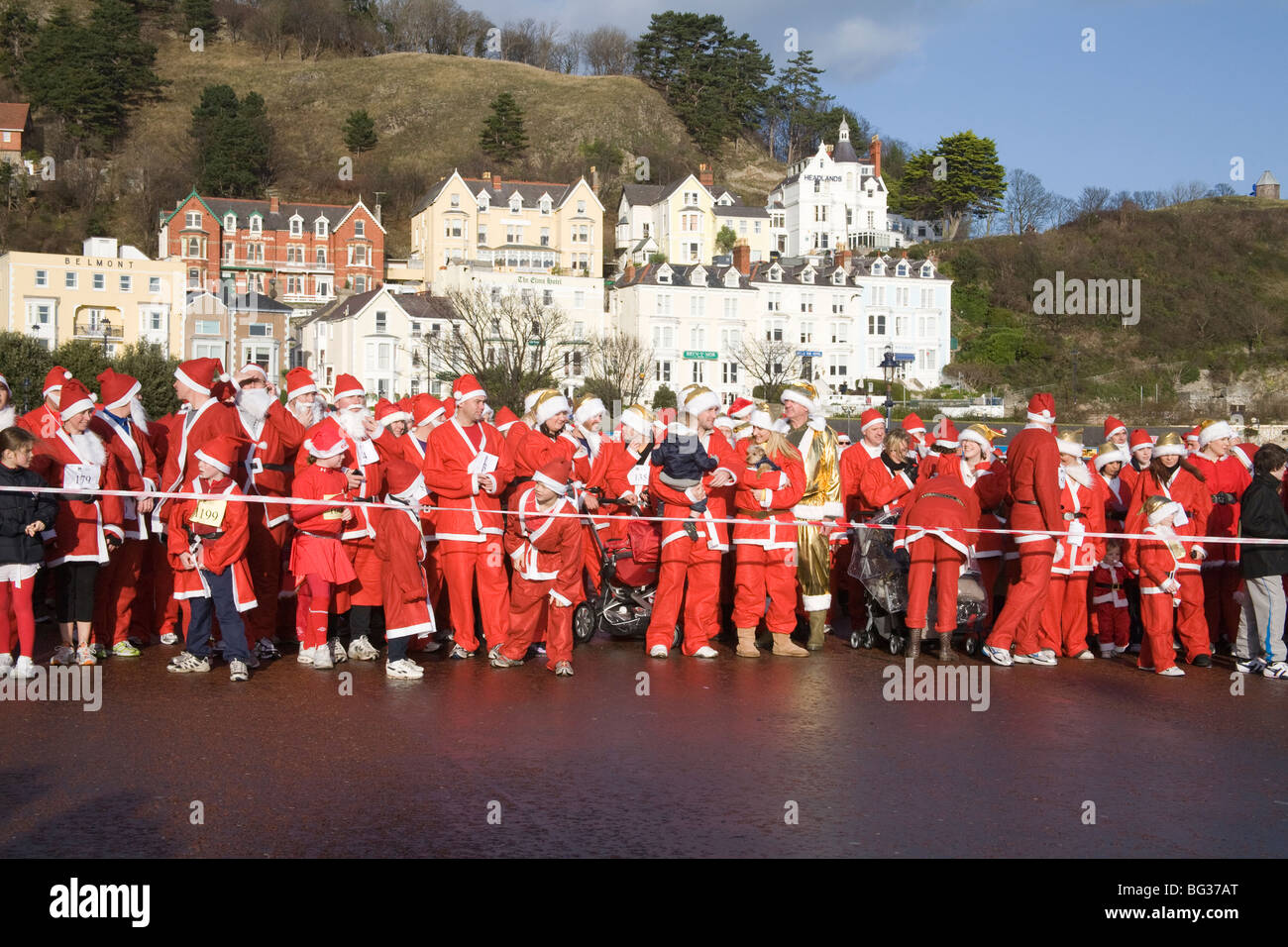 Llandudno North Wales UK dicembre i partecipanti nell'annuale Santa run per carità allineando sul lungomare la raccolta di fondi per le buone cause Foto Stock