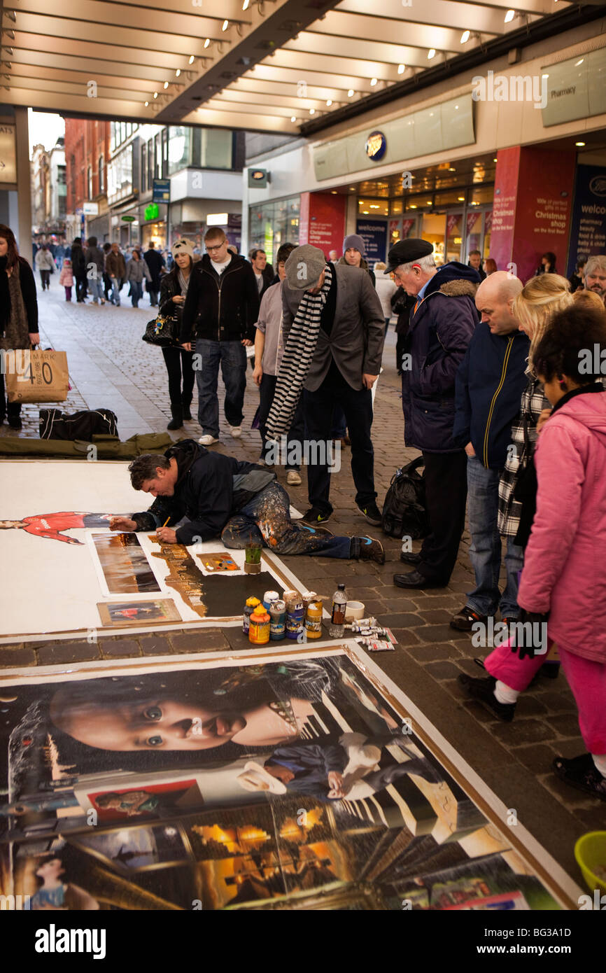 Regno Unito, Inghilterra, Manchester, Market Street, Salford artista Anthony Debro lavorando su larga scala la verniciatura sul marciapiede Foto Stock