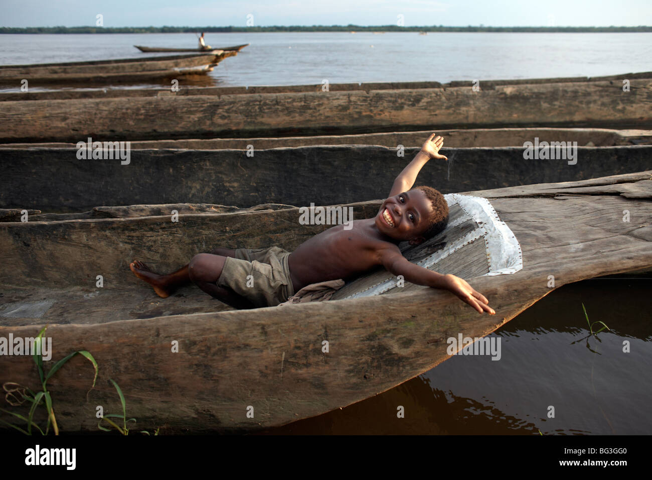 Un ragazzo si rilassa in una piroga sul fiume Congo, Yangambi, Repubblica Democratica del Congo, Africa Foto Stock
