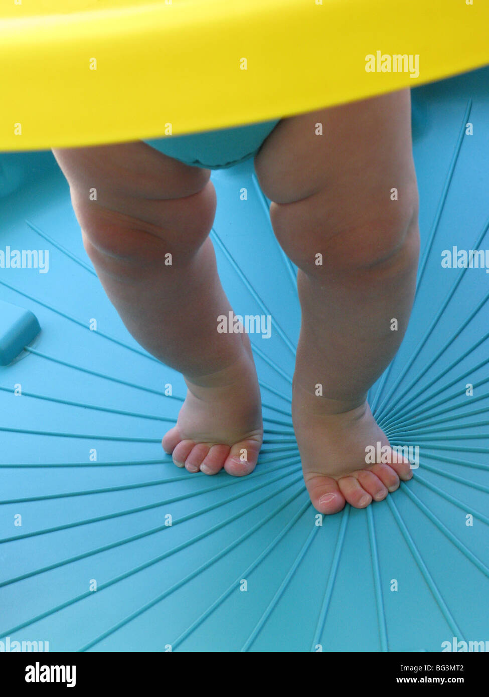 Gambe e piedi di un bambino ad imparare a camminare in un ambiente di blu Foto Stock