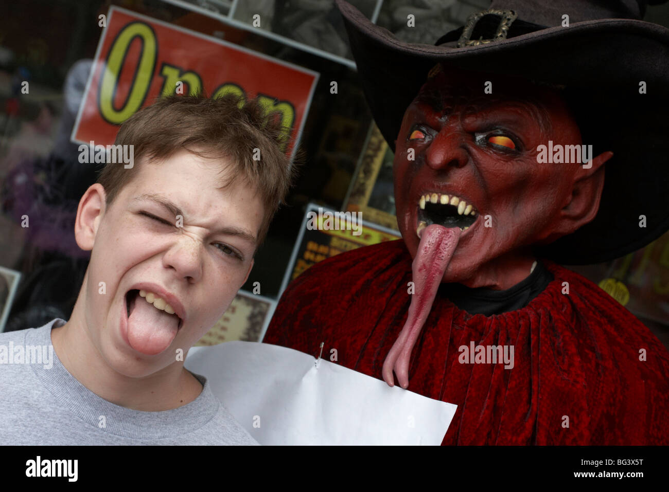 Un ragazzo con la sua lingua appeso accanto a un demone manichino con la lingua pendente in fuori Foto Stock