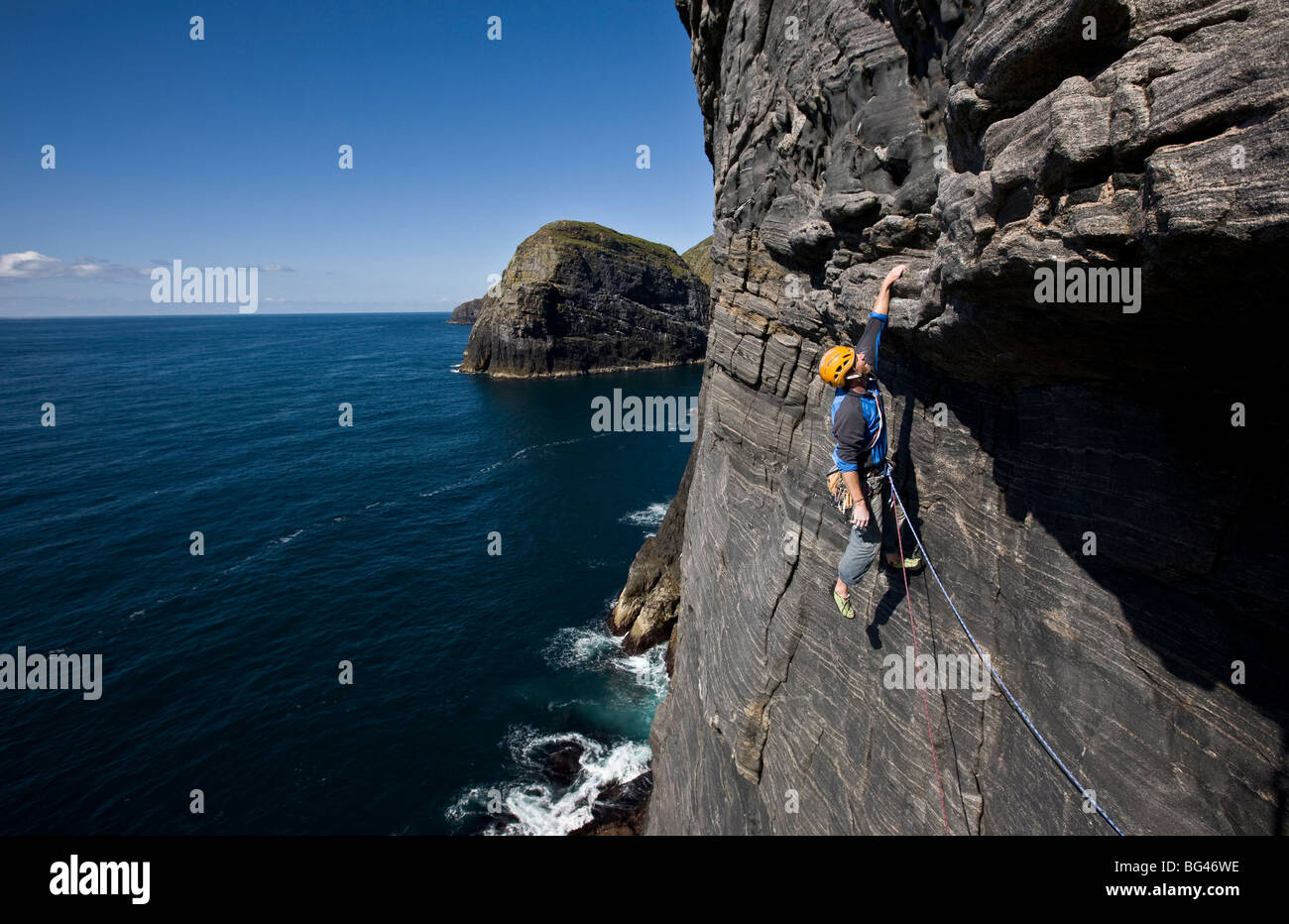 Un alpinista è appeso sopra il mare,west volto di Dun Mingulay cliff, Mingulay Isola, Ebridi Esterne, Scotland, Regno Unito Foto Stock