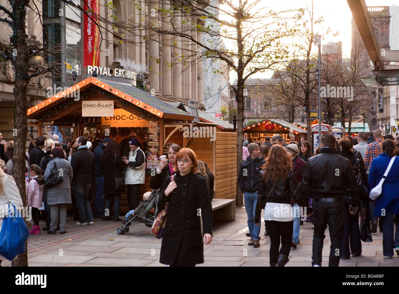 Regno Unito, Inghilterra, Manchester, St Annes Piazza Mercato di Natale shoppers queueing in stallo al cioccolato Foto Stock