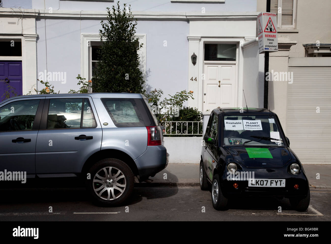 G-Wiz (AEV elettrica automatica) del veicolo parcheggiato di fianco. Il verde di soluzione di trasporto. Foto Stock