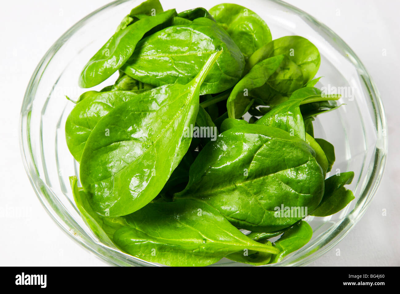 Baby spinaci foglie in una ciotola di vetro Foto Stock