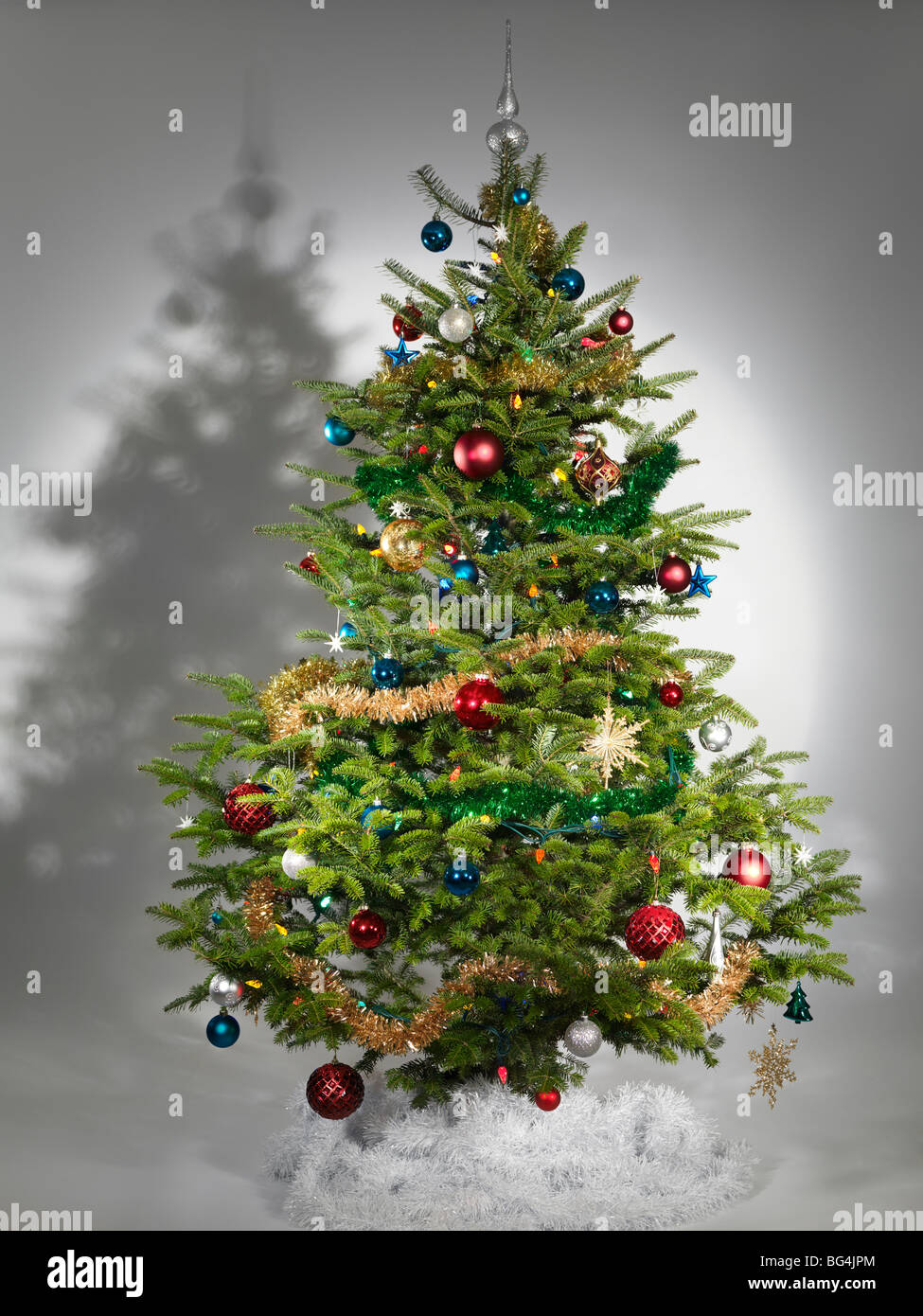 Decorate albero di Natale vero isolato su sfondo grigio Foto Stock