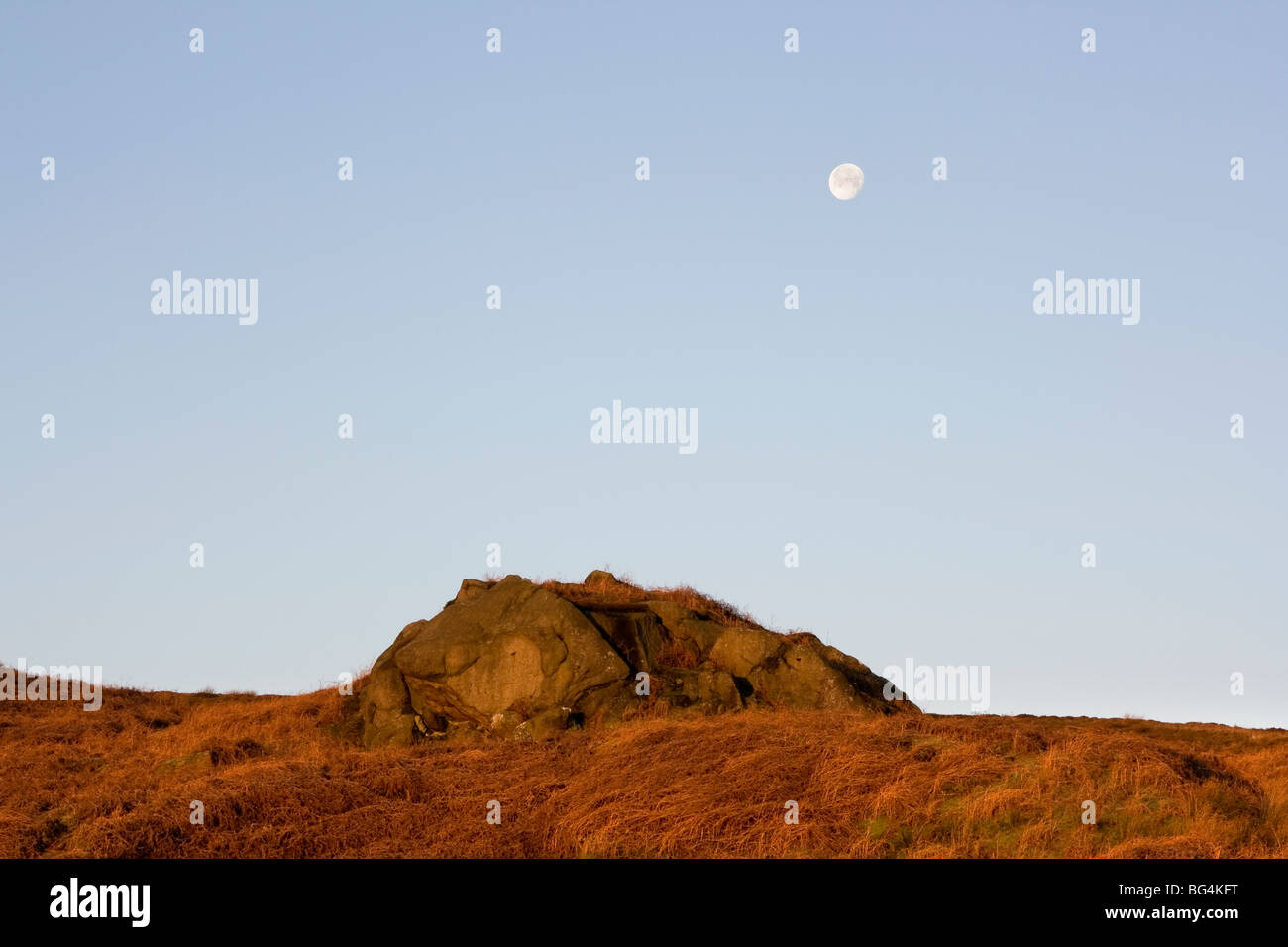 Alba e la luna splende ancora al di sopra di rocce sulla Embsay Moor, nel North Yorkshire, Regno Unito Foto Stock