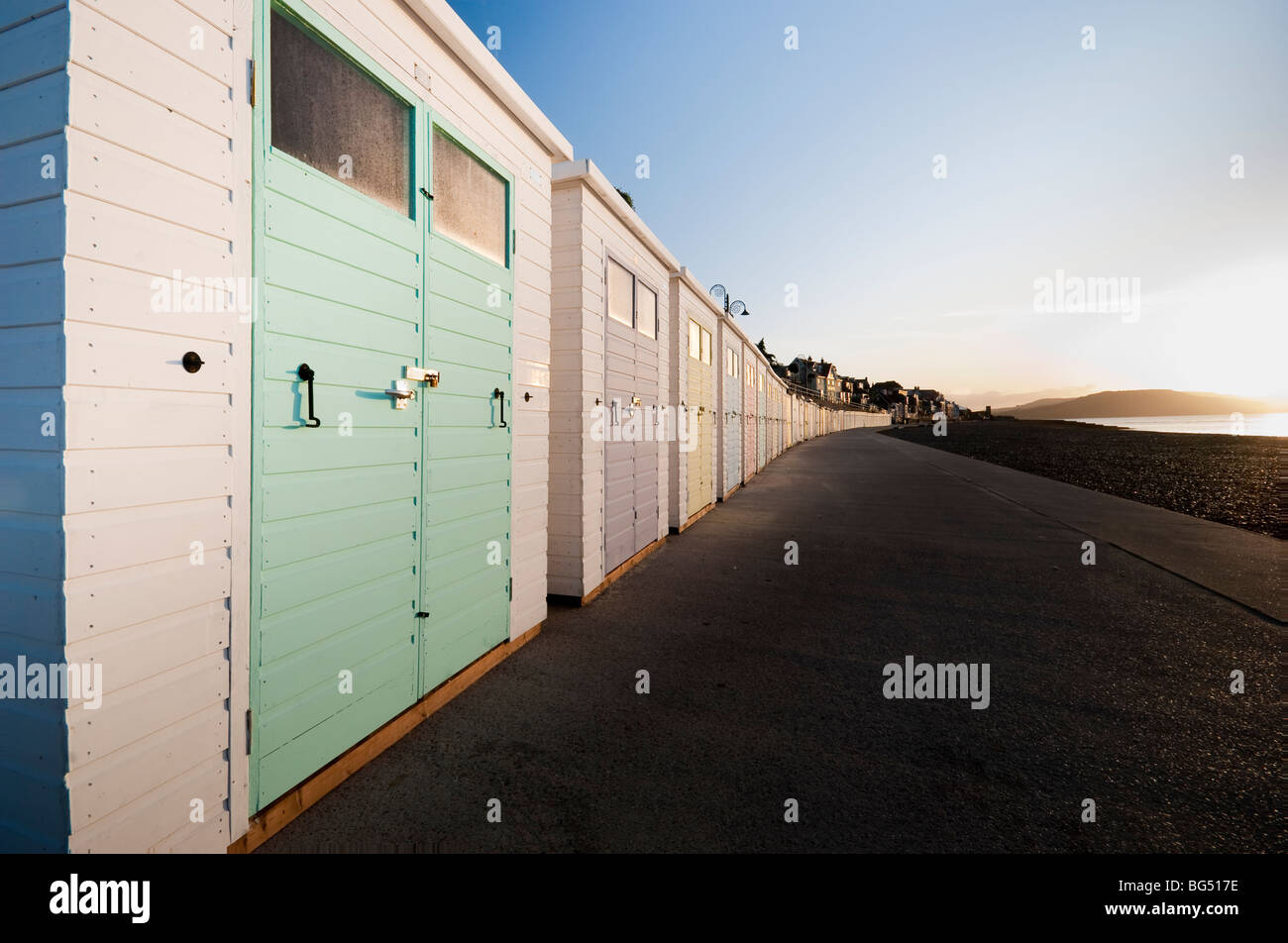 Lyme Regis cabine sulla spiaggia, all'alba Foto Stock