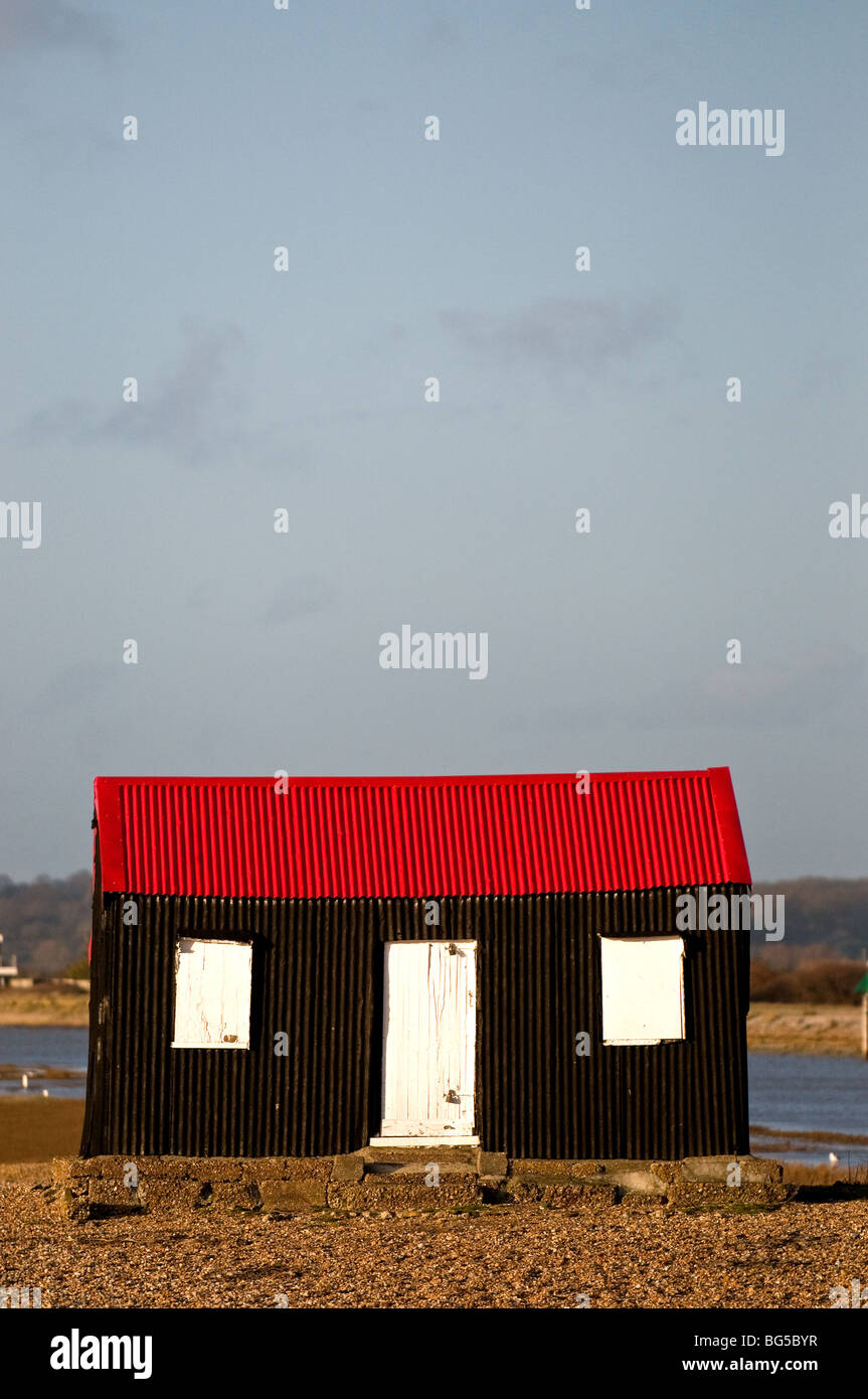 Un edificio con un tetto di ferro ondulato rosso vicino a Rye in East Sussex. Foto Stock