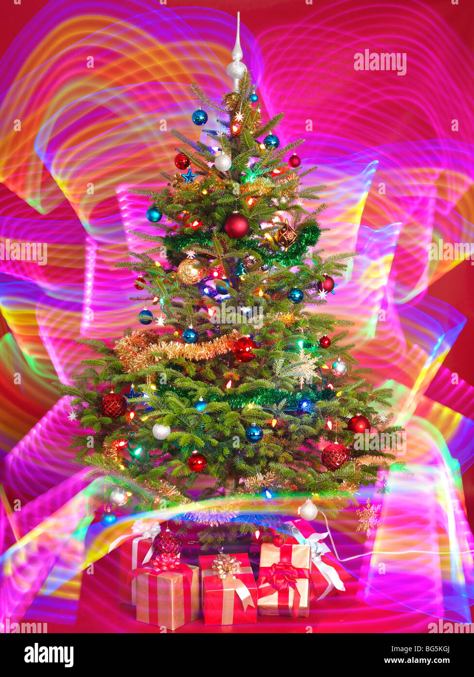 Albero di Natale decorato con viola gli effetti di illuminazione intorno ad esso Foto Stock