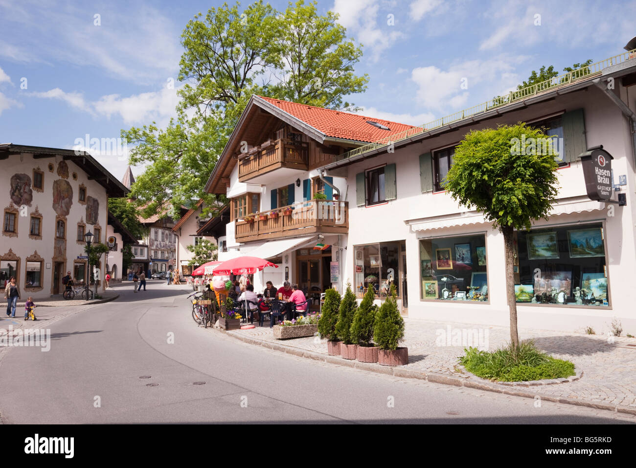 I negozi per turisti, edifici alpini e pavement cafe nella città bavarese. Oberammergau Baviera Germania Europa. Foto Stock