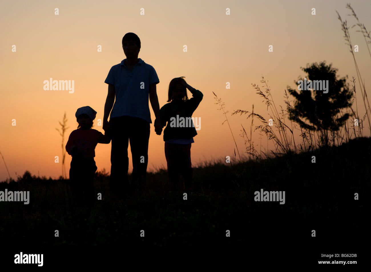 Mater e bambini - silhouette dal tramonto Foto Stock