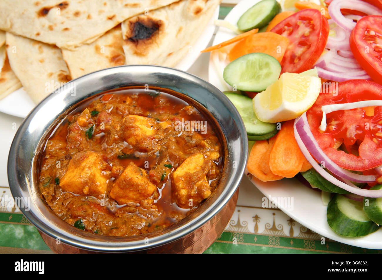 Kadai paneer curry di formaggio in un sugo di cardamomo, con pane naan e un'insalata a parte Foto Stock