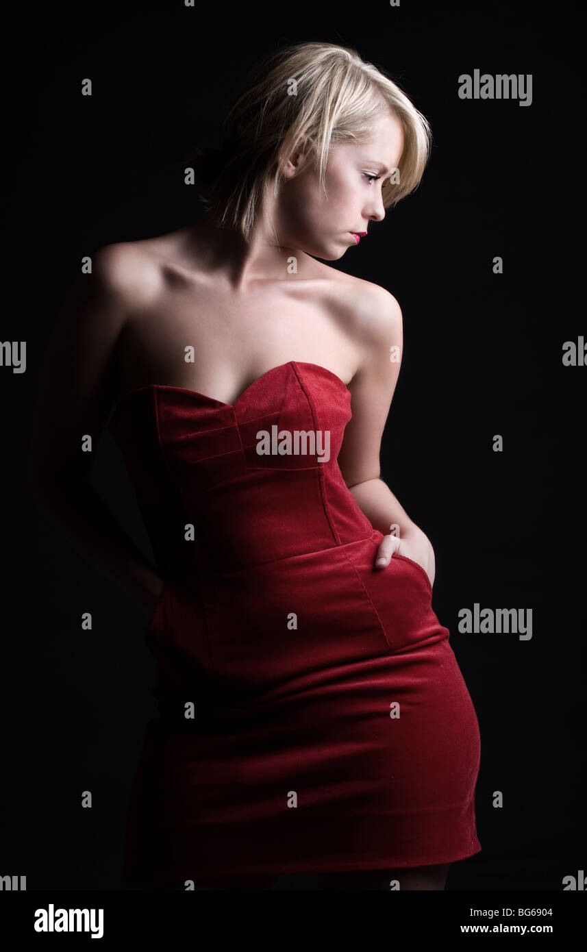 Tasto basso colpo di una splendida ragazza bionda in abito rosso Foto Stock
