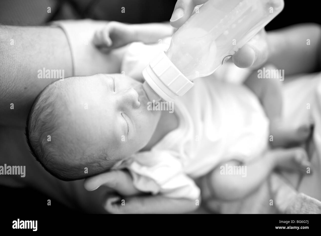 Il padre del bambino di alimentazione figlio un biberon di latte. Foto Stock