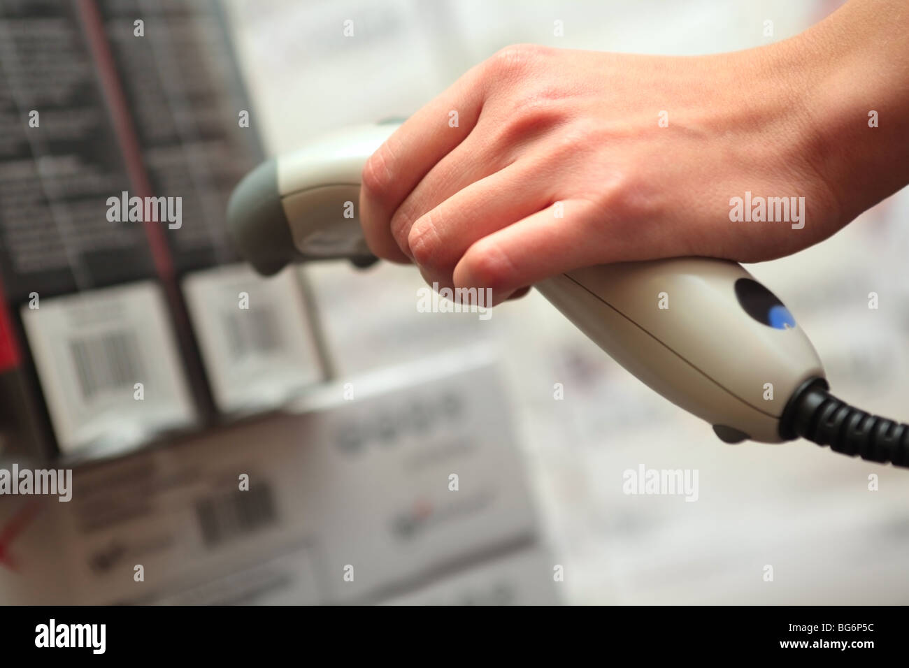 Store. Lettore di codici a barre in mano della ragazza. DOF poco profondo. Foto Stock