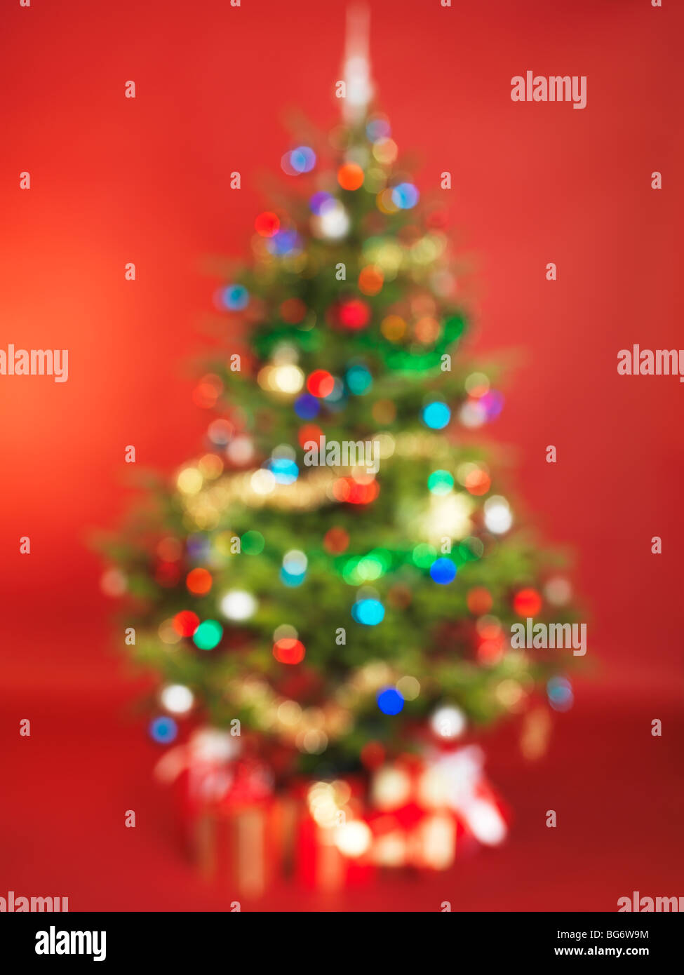 Al di fuori della messa a fuoco albero di Natale decorato isolato su sfondo rosso Foto Stock