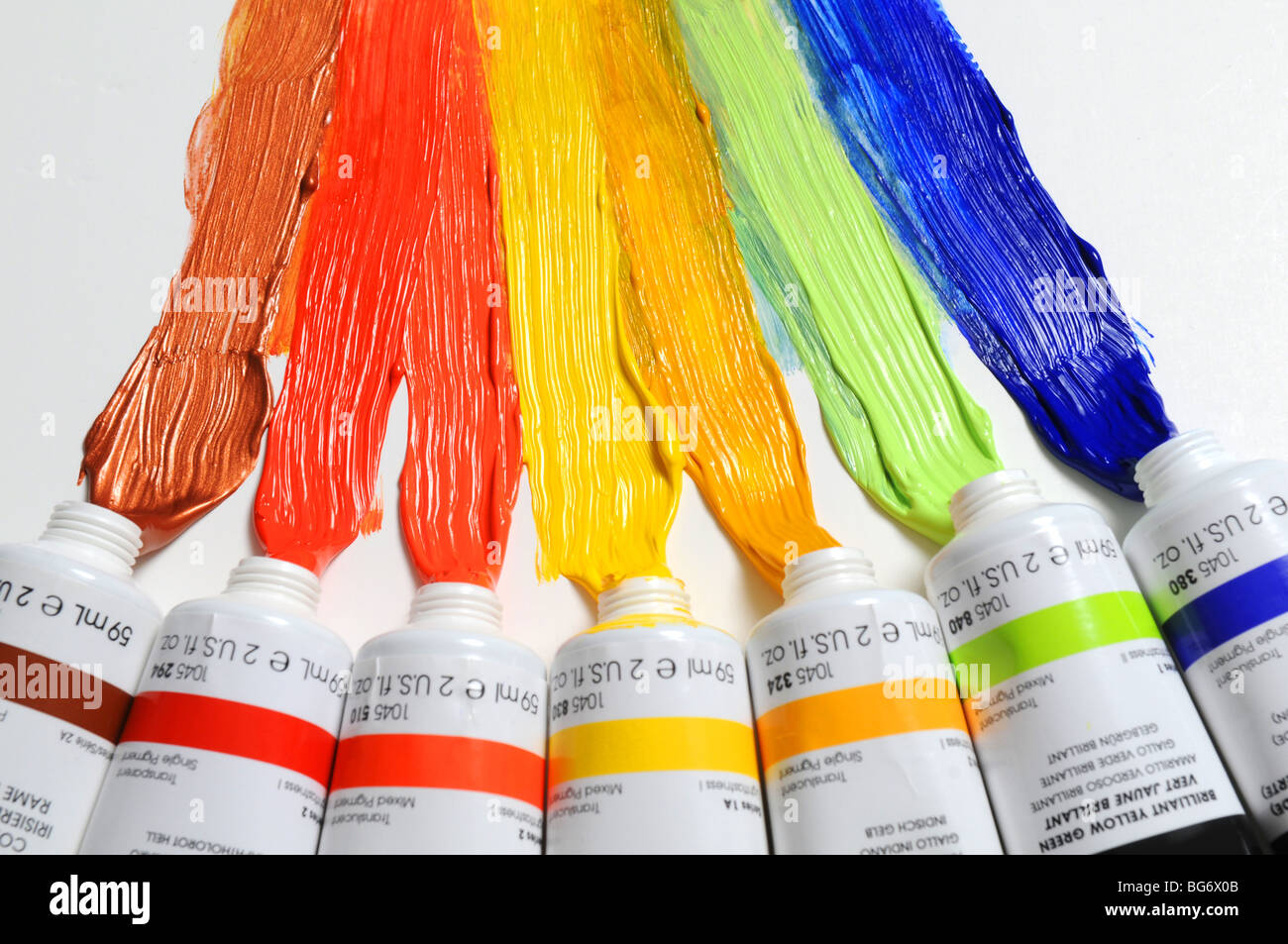 La vernice di diversi colori sparsi su uno sfondo bianco Foto Stock