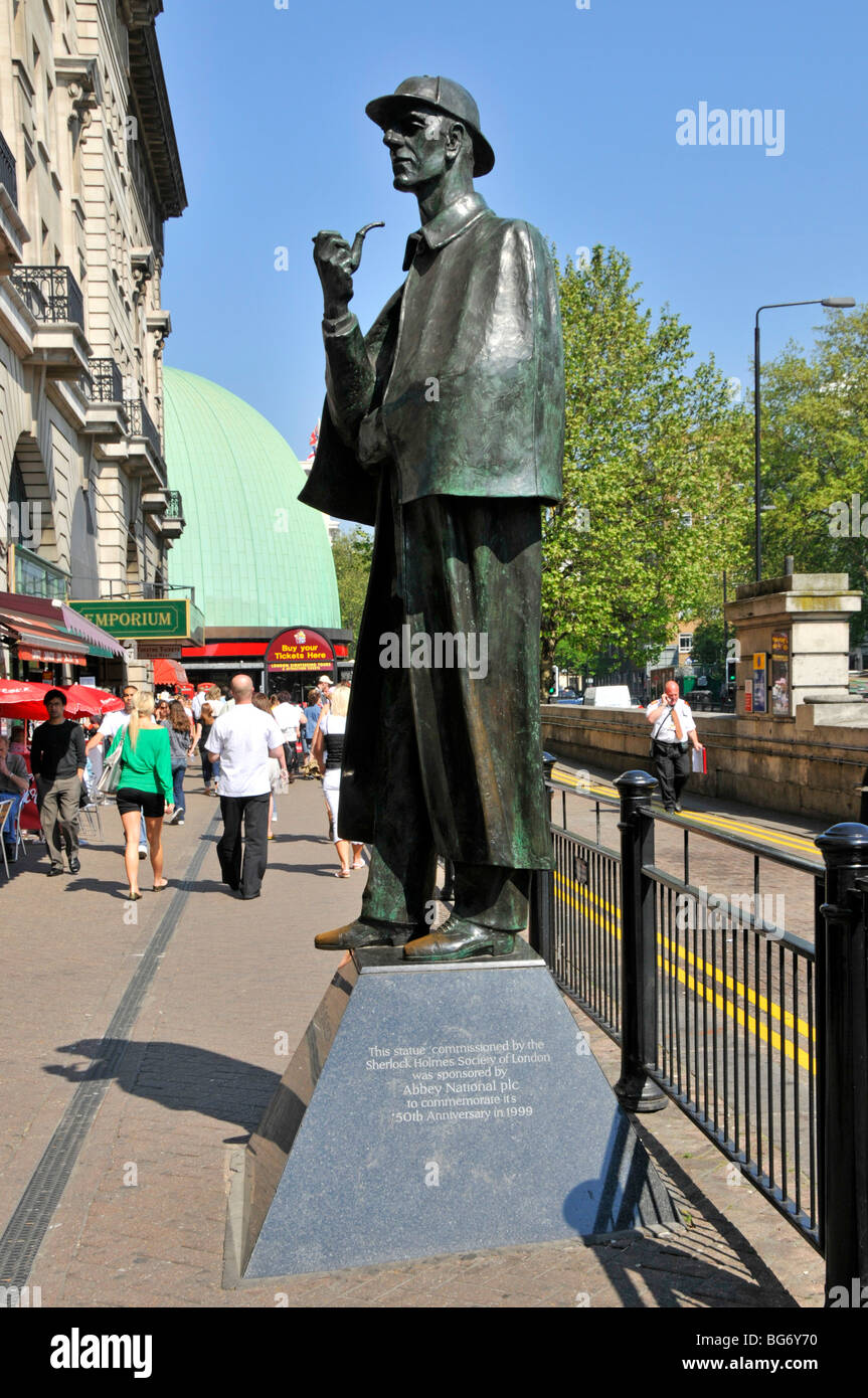 Scena di strada scultura a lunghezza intera Sherlock Holmes come statua di bronzo con iscrizione sul mantello di tubo di base faccia & cappello su Marylebone Road Londra UK Foto Stock