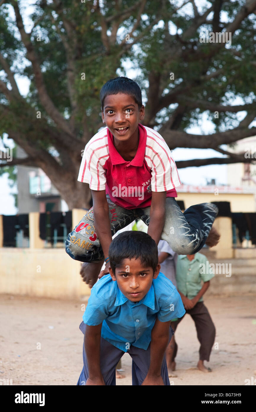 Villaggio indiano ragazzi giocare leap frog gioco. Nallaguttapalli, Andhra Pradesh, India Foto Stock