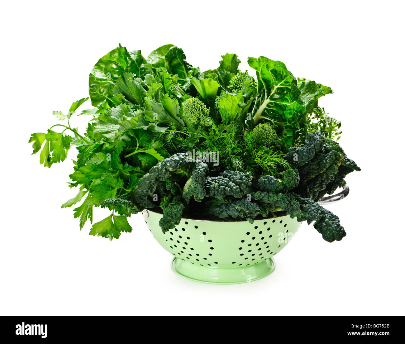 Verde scuro frondosa ortaggi freschi in metallo scolapasta isolato su bianco Foto Stock