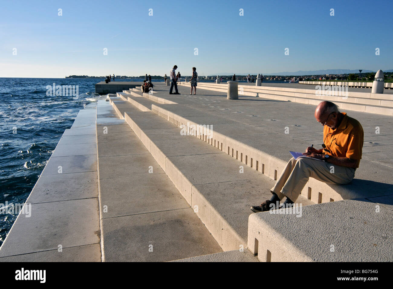 Visitatori presso l'organo marino, strumento musicale in modalità di  riproduzione audio dalle onde del mare e i tubi sotto gradini in marmo Nova  costa di Zadar, Croazia Foto stock - Alamy