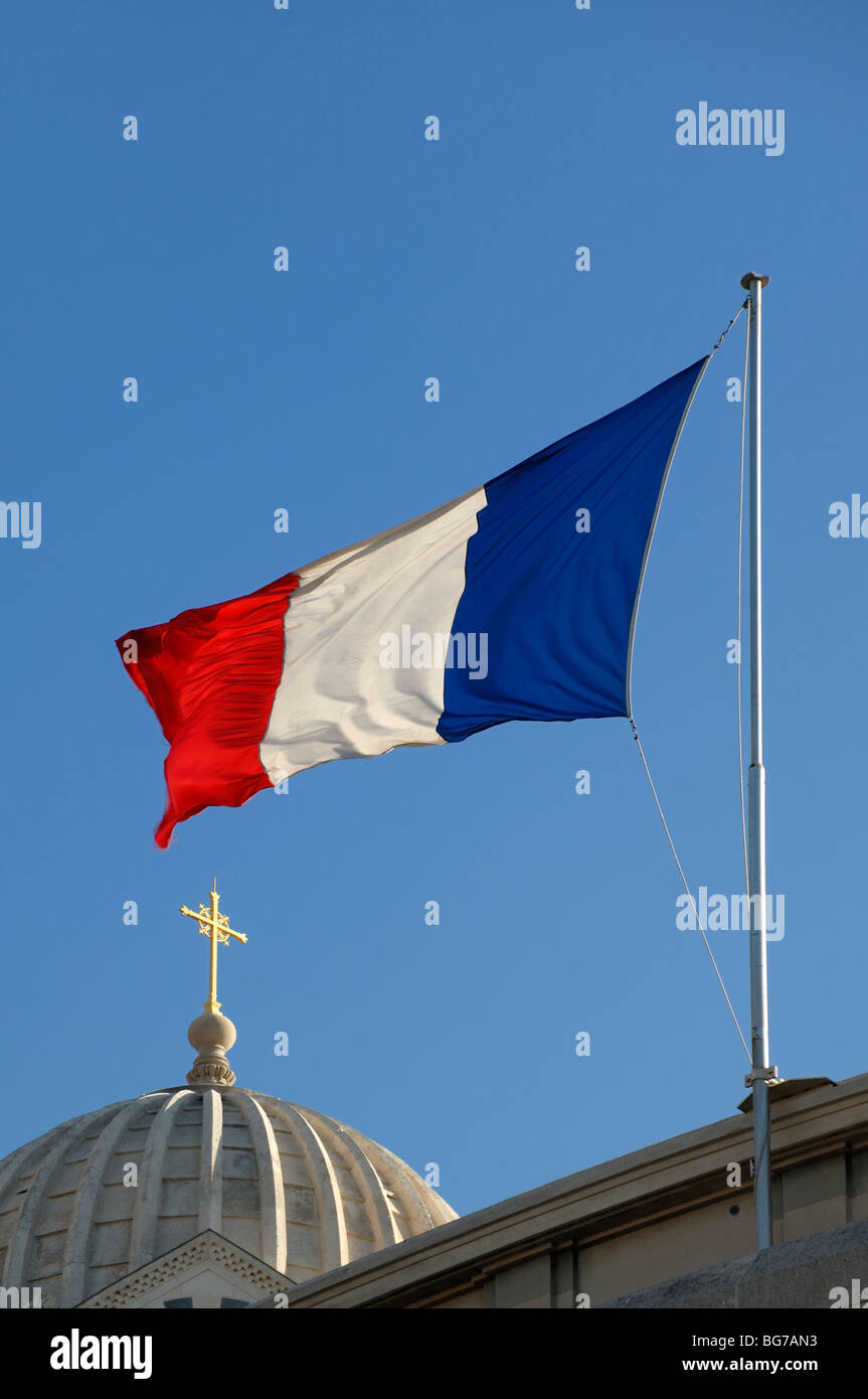Chiesa Duomo, Cross & bandiera francese che volano sopra la cattedrale di Notre Dame de la Garde Chiesa, Marsiglia o Marsiglia Provenza, Francia Foto Stock