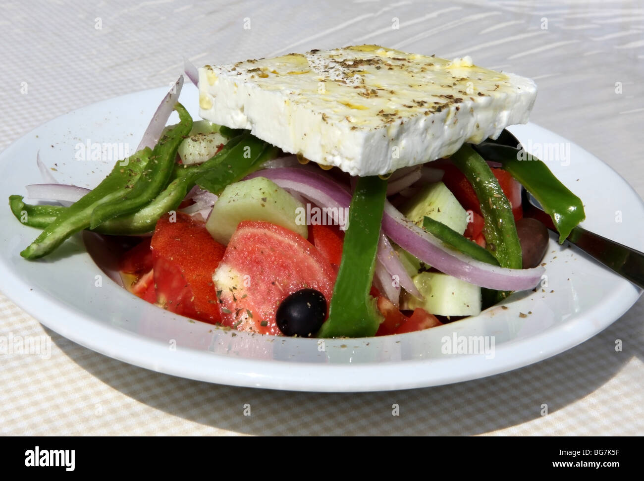Tradizionale insalata greca servita con una grande fetta di formaggio feta Foto Stock