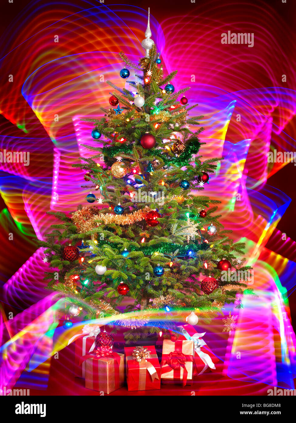 Albero di Natale decorato con viola gli effetti di illuminazione intorno ad esso Foto Stock