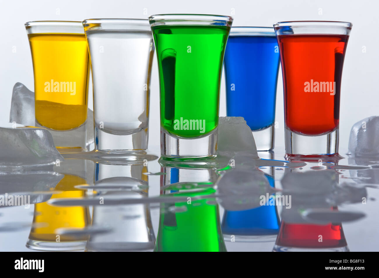 Still-life da cinque piccole pile dal vetro, riempito cocktail di colore con la riflessione e il ghiaccio Foto Stock