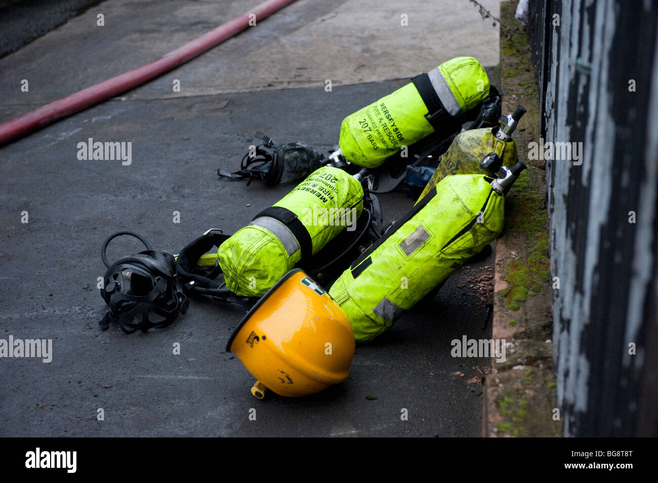 Quattro Vigili del fuoco respirazione cilindri ad aria e casco Foto Stock