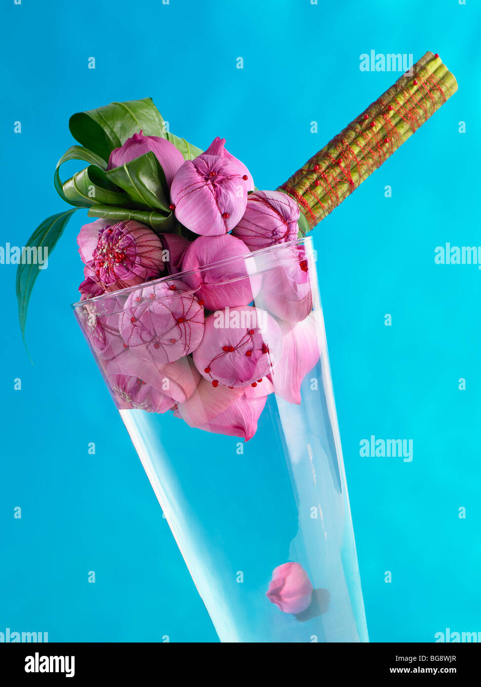 Pink lotus boccioli di fiori legati in un mazzo di fiori in un vaso su sfondo blu Foto Stock
