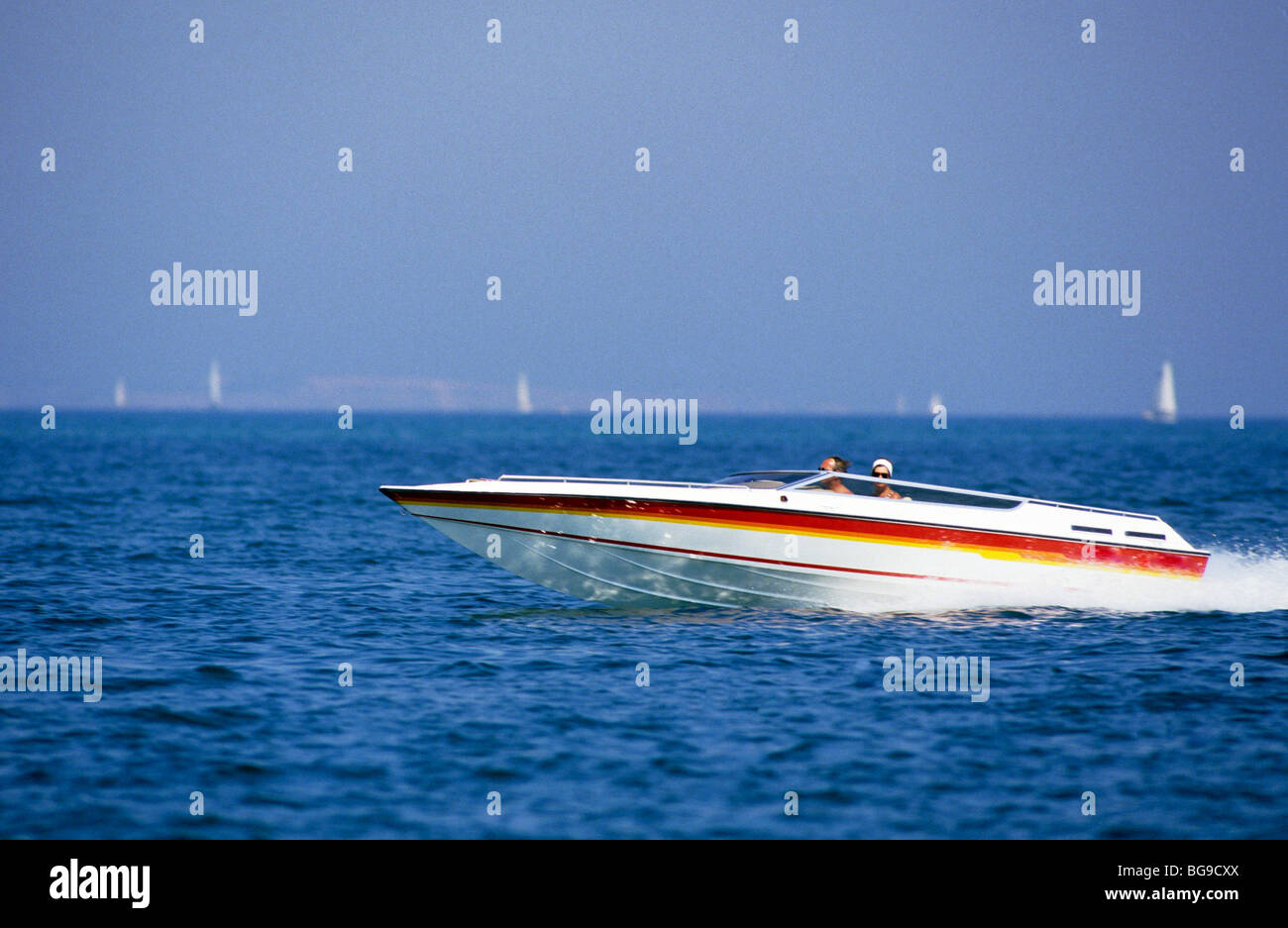 Tempo libero offshore powerboat attraverso tagli litorale con yachts in background Foto Stock