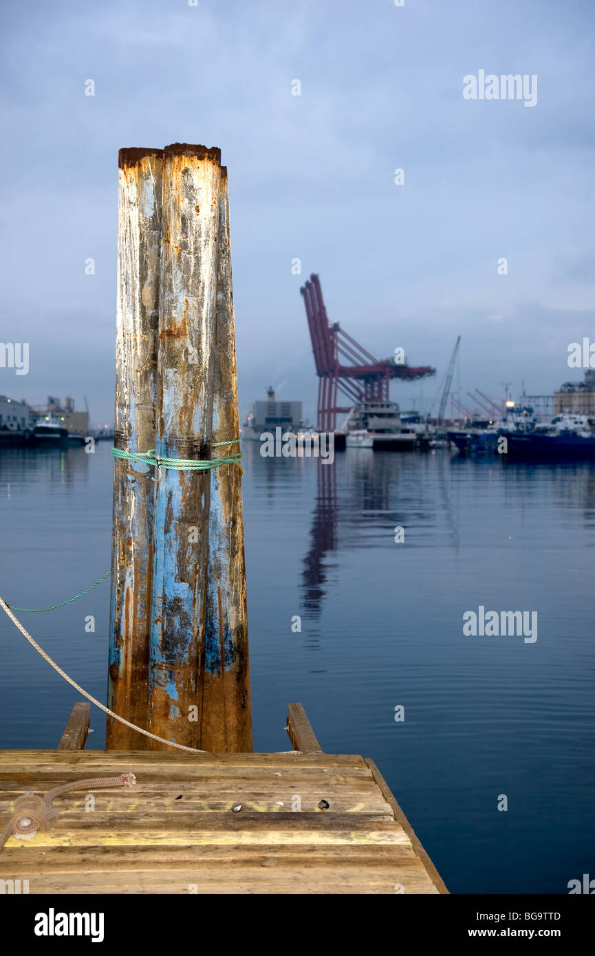 Un pontile e dock durante un molto presto, grigio e nuvoloso al mattino si affaccia un commerciale il carico e lo scarico di dock per il commercio. Foto Stock