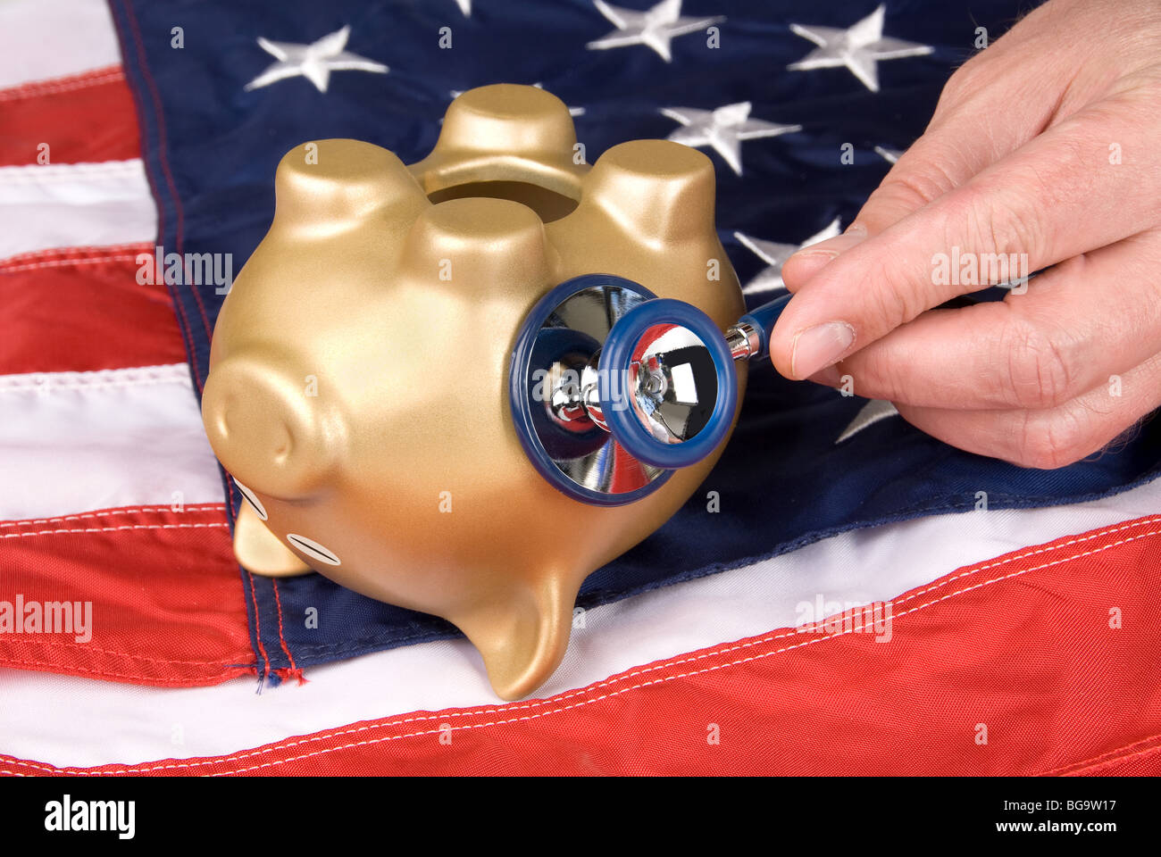 Un capovolto, quasi morto salvadanaio su una bandiera americana è in fase di esame per i segni di vita economica e finanziaria. Foto Stock