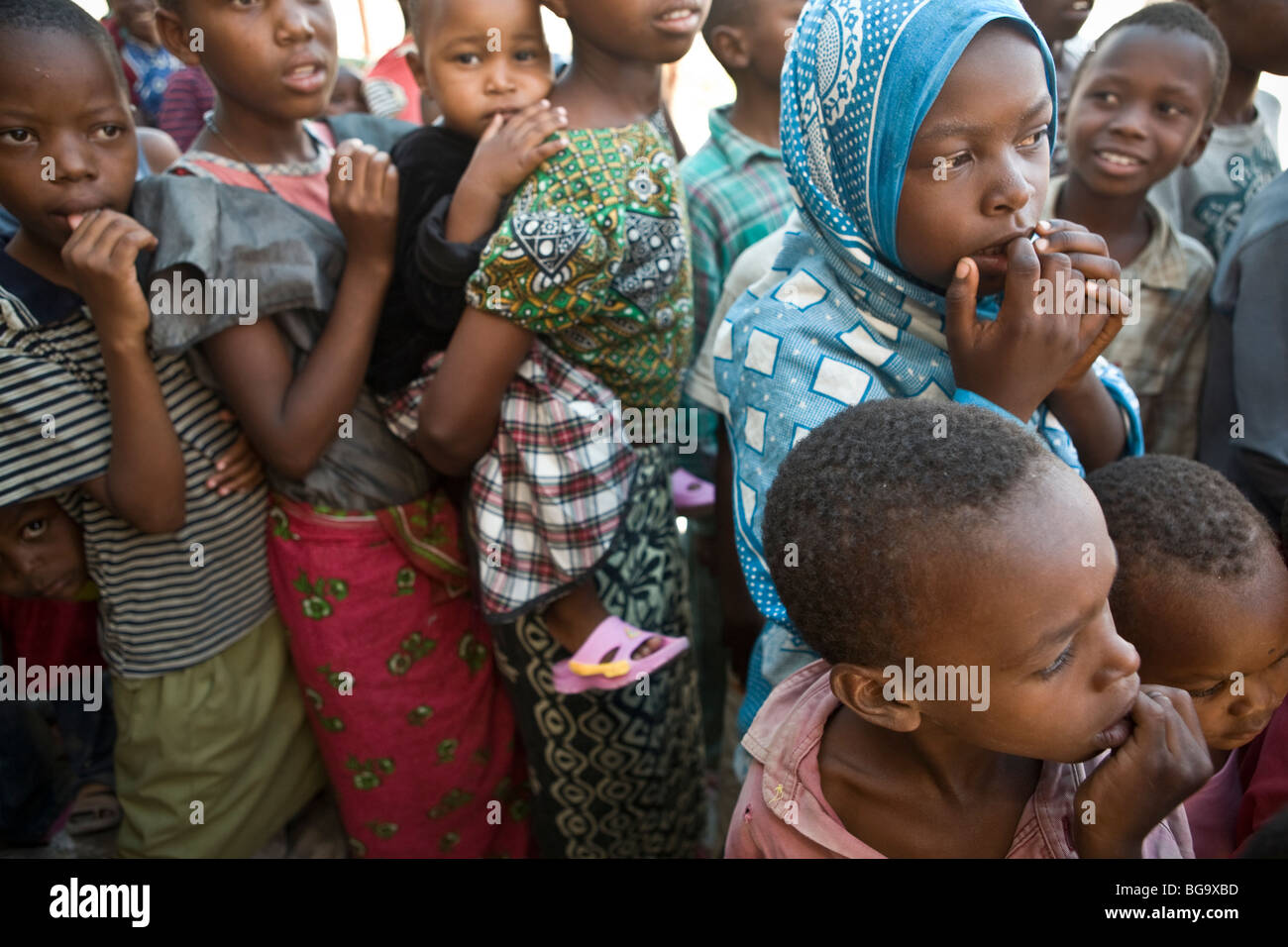 I bambini in attesa in una distribuzione di cibo in coda Mererani, Tanzania, il mondo solo fonte nota della gemma Tanzanite. Foto Stock